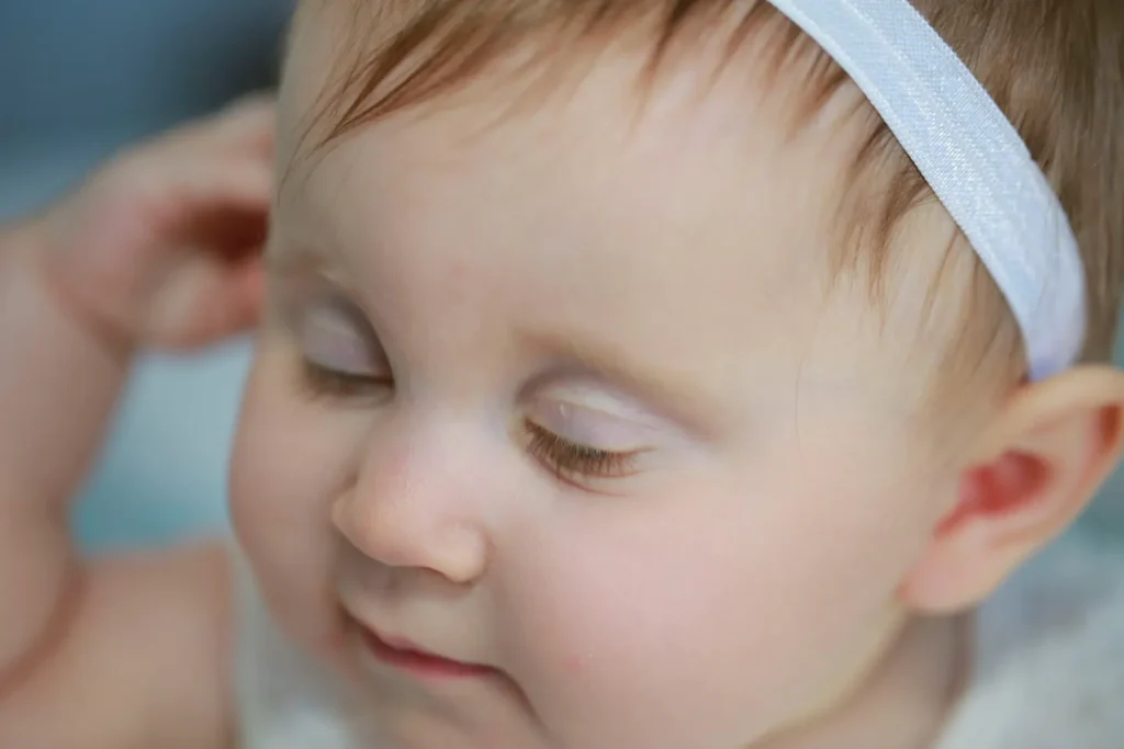 Soft close-up portrait of a baby girl with natural expression and delicate styling