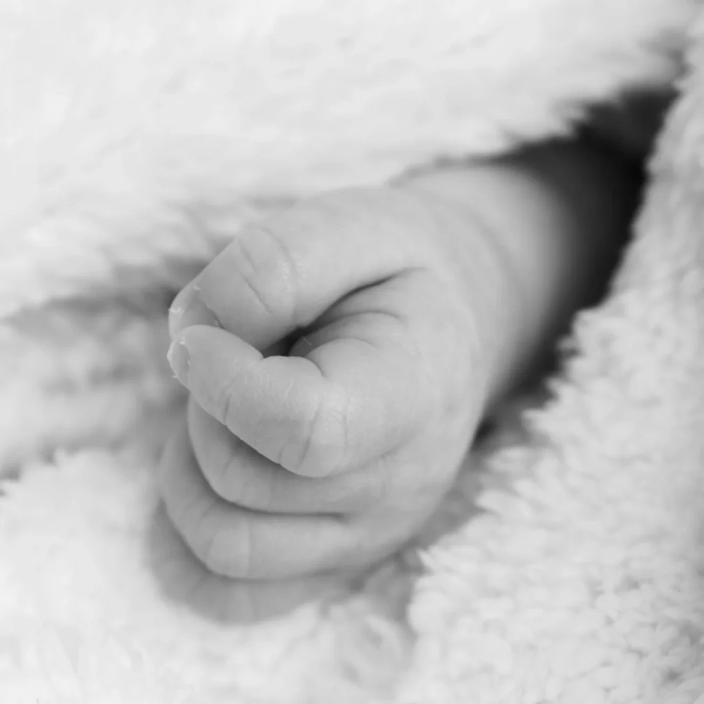 Close-up black and white portrait of a newborn baby’s curled hand